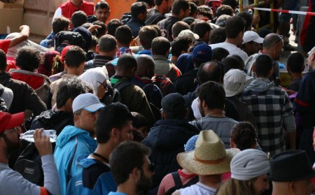 Migrants wait in Nickelsdorf, Austria,   at the border between Hungary and Austria, Thursday, Sept. 10, 2015. Austrian police say more than 3,000 migrants crossed into Austria overnight at Nickelsdorf, the main border point with Hungary. (ANSA/AP Photo/Ronald Zak)